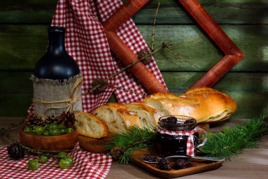 Rustik natürmort ekmek ve reçel. Ekmek, Bektaşi ve reçel çam kozalakları eski duvar arka planı üzerinden.