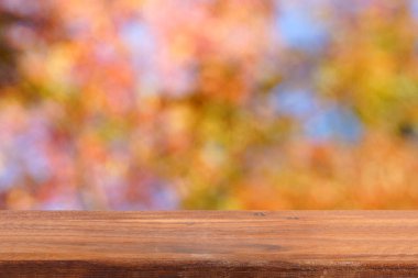 Boş ahşap masa. Renkli arka plan bulanık.