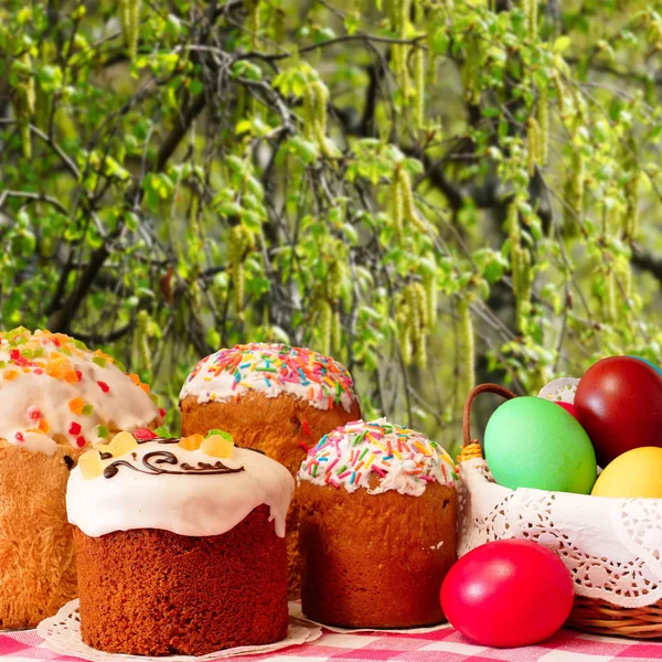 stock image Easter. Cupcakes and painted eggs. Blurred background. Easter cakes and colorful eggs on the background of flowering birch.