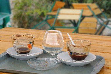 Ahşap masada kahve ve konyak boş bardak. Tatil sezonunun sonu.
