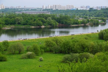 Moskova, Rusya - 12 Mayıs 2019. Moskova Nehri ve Maryino bölgesi manzarası. İnsanlar Kolomenskoye parkta dolgu boyunca yürümek.