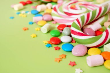 Şeker. Yeşil bir arka plan üzerinde çok renkli tatlılar ile tebrik arka plan. Metin için boş alan.