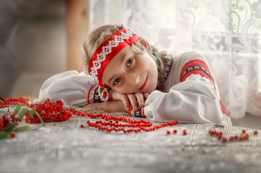 Halk kostümü giymiş güzel bir Rus kız masaya uzandı. Geleneksel kostümlü bir kızın portresi. Rus geleneği.