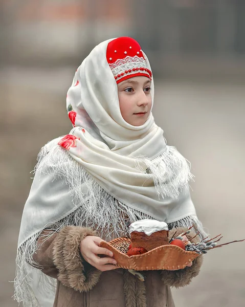 一个戴头巾的女孩拿着一个装有蛋糕和鸡蛋的托盘作为复活节礼物 一个身穿民族服装的俄罗斯女孩的画像 俄罗斯复活节 — 图库照片