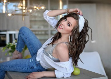 Beyaz gömlekli güzel bir kız ve yeşil elmalı bir masada mavi kot pantolon. Beyaz iç çamaşırlı genç bir kadının portresi..