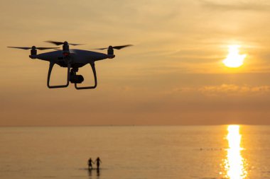 profesyonel casus uçak dört helikopter ile gözetleme için uçmaya hazır gün batımında dijital fotoğraf makinesi. Rotor Uav Close-up. dört uç pervane dron. siluet helikopter üzerinde güzel gün batımı.