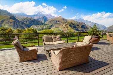 Yüksek dağın tepesinde Kazbek, Kafkas Dağları ve Gergeti Trinity Kilisesi Tsminda Sameba, Holy Trinity Kilisesi manzaralı bir teras kafe güzel manzara. Stepantsminda, kazbegi, Georgia.
