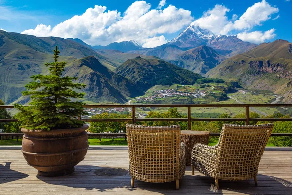 Yüksek dağın tepesinde Kazbek, Kafkas Dağları ve Gergeti Trinity Kilisesi Tsminda Sameba, Holy Trinity Kilisesi manzaralı bir teras kafe güzel manzara. Stepantsminda, kazbegi, Georgia.