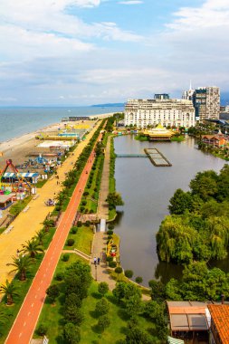 Batumi 'nin şarkı söyleyen fıskiyelerinin yanındaki yeni Batumi Bulvarı' nın seti boyunca bisiklet yolunun güzel manzarası. Batum ve Karadeniz kıyısında palmiye ağaçları olan bir park.