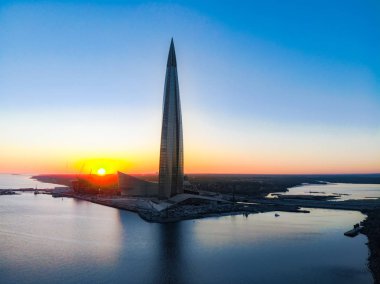 Saint Petersburg, Rusya - 16 Nisan 2019: Kamu, iş kompleksi Lakhta merkezi, Gökdelen Gazprom genel merkezi. Finlandiya Körfezi. Gün batımında mavi gökyüzünü temizleyin. Sudaki yansıma. En iyi görüntü hava drone