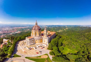 Beautifull aerial panoramic view to the famous from the drone Basilica of Superga in sunny summer day. The cathedral church located at the top of hill in italian Alps mountains. Turin, Piedmont, Italy clipart