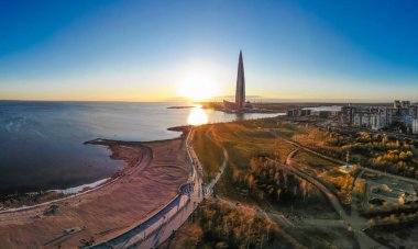 Saint Petersburg, Rusya - 16 Nisan 2019: Kamu, iş kompleksi Lakhta merkezi, Gökdelen Gazprom genel merkezi. Finlandiya Körfezi. Gün batımında mavi gökyüzünü temizleyin. Sudaki yansıma. En iyi görüntü hava drone