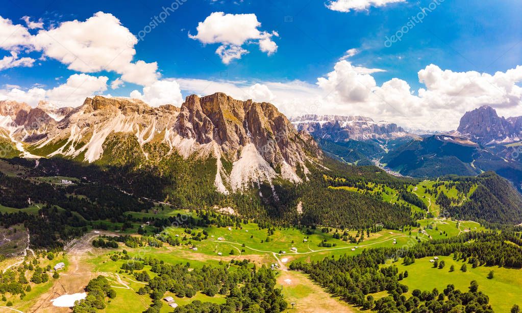 Aerial top view from drone to Col Raiser plateau In sunny summer Day. Scenery of rugged Sella Mountain with green valley on grassy hillside village St. Cristina di Val Gardena, Bolzano, Seceda Italy.