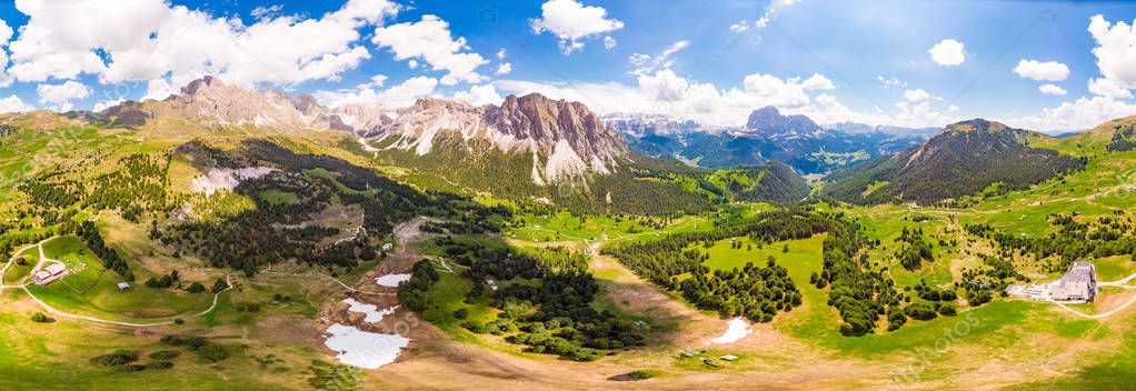 Aerial top view from drone to Col Raiser plateau In sunny summer Day. Scenery of rugged Sella Mountain with green valley on grassy hillside village St. Cristina di Val Gardena, Bolzano, Seceda Italy.