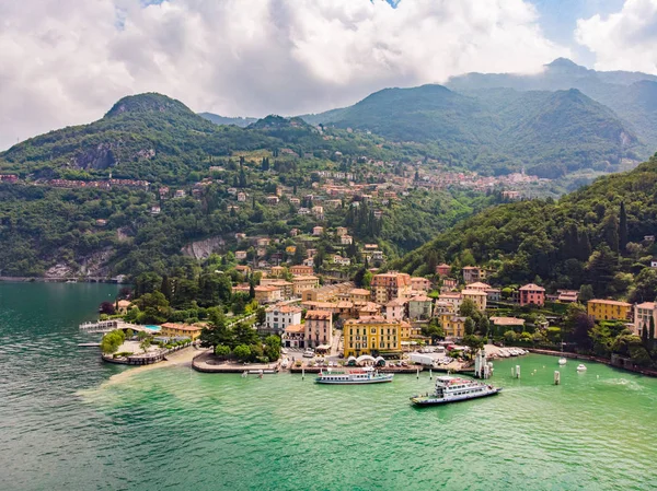 Como gölü kıyısında ünlü eski İtalya şehir - Varenna için drone Beautifull havadan panoramik görünümü. Güneşli yaz gününde yeşil tepeler, dağlar ve şehir ile Su manzara yüksek üst görünümü. — Stok fotoğraf