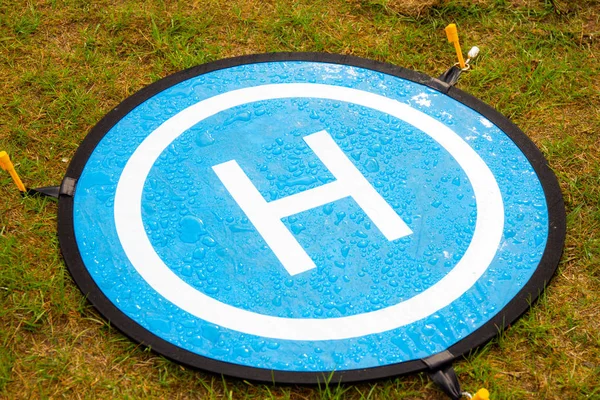 Su damlaları ile drone için mavi iniş yeri. İniş Park Pad helikopter için platform çıkarmak yüksek fiyatlı bir uçağın bozulmasını tahrif etmek için yüksek çim ve tozlu zemin kullanılır