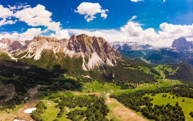 Güneşli yaz gününde drone'dan Col Raiser platosuna havadan üstten manzara. Çimenli yamaç köyü St Cristina di Val Gardena, Bolzano, Seceda İtalya yeşil vadi ile engebeli Sella Dağı Manzarası.