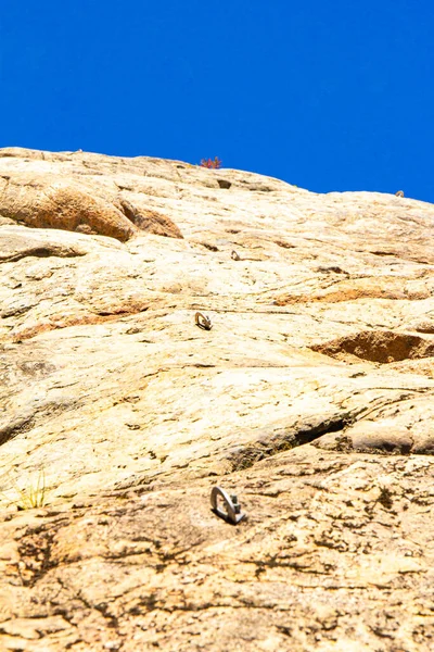 Close-up view to Steel anchor on a rock wall. Outdoor equipment. Climbing track from fastening screws. Bolt hammered into the cliff used for insurance of climbers in the mountains. Karelia, Russia. — Zdjęcie stockowe