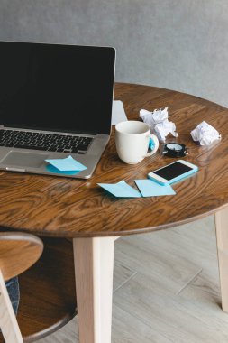 Ofis İşyeri dizüstü bilgisayar, kahve fincanı ve ahşap masa üstünde smartphone