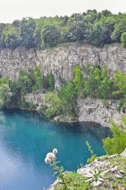 Yaz manzarası gölü. Kayalık kıyılar arasında turkuaz su.