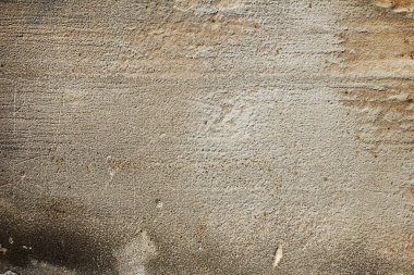 Eski gri beton bir duvarın dokusu lekeler ve çizikler halinde.