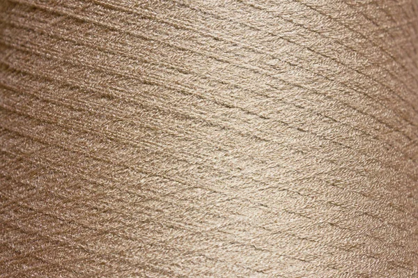 ベージュの背景 コイル状の糸の大きなボビンの質感 — ストック写真