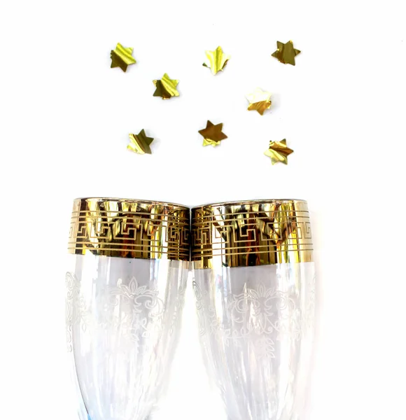 Two glasses of champagne and gold stars. Isolated on white backgroun