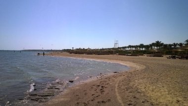 Sahilde Mısır 'da bir tatil köyünde alçak gelgitte arka planda dağlarla