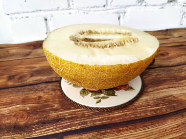 Tahta bir masada yarım olgun kavun.