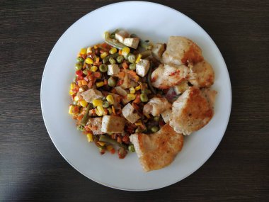 Sebze ve soya peynirli kızarmış tavuk parçaları.