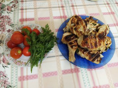 Barbekü tavuk ve sebzeler masada.