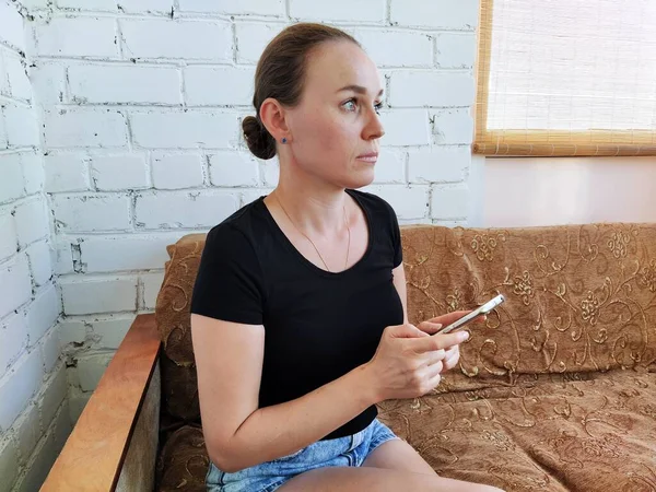 Millennial Frau Sitzt Auf Dem Sofa Und Telefoniert Mit Ruhiger — Stockfoto