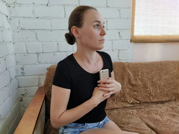 Millennial Frau Sitzt Auf Der Couch Drückt Sich Das Telefon — Stockfoto