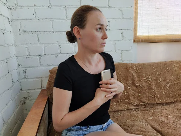 Millennial Frau Sitzt Auf Der Couch Drückt Sich Das Telefon — Stockfoto