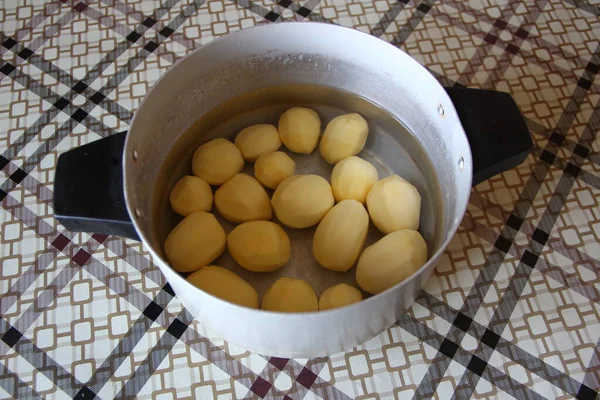Tencerede soyulmuş patates.