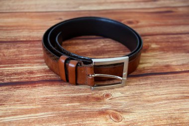 Ahşap arka planda kahverengi deri kemer