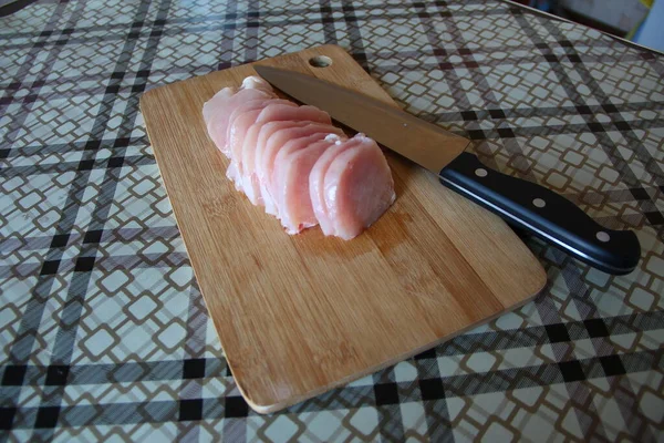 用刀把鸡胸肉切碎在切菜板上 — 图库照片