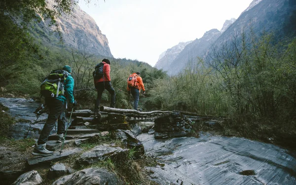 히말라야를 하이킹하는 일단의 등산객들이 다리를 건넌다 스톡 이미지