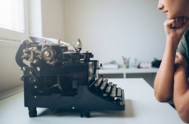 Daktilo makinesinde oturan genç kadına yaklaş.