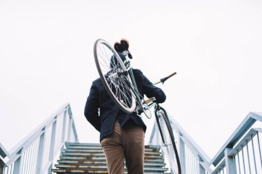 Bisikletli hippi eğleniyor. Sakallı adam parkta bisiklet sürmeyi sever.