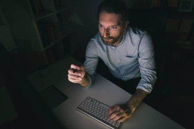 İşadamı uzun saatler bilgisayar başında çalışıyor.