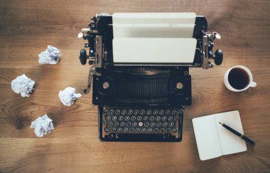 Kırsal ahşap arka planda eski bir daktilo ve buruşuk kağıtlar. İlham sorunu kavramı