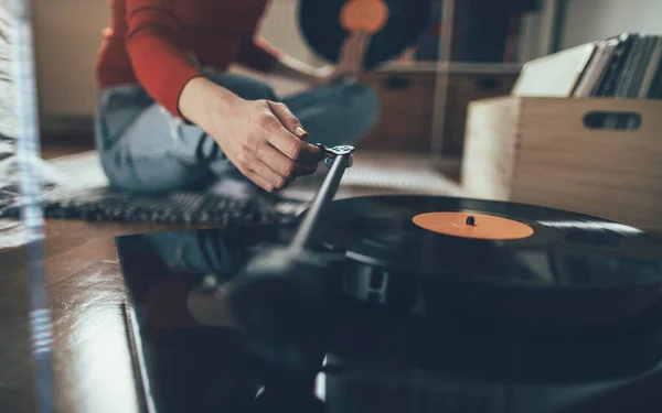 レコードを再生する 床に座ってターンテーブルで音楽を演奏する女性の作物のショット — ストック写真
