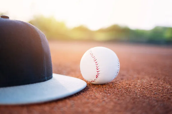 Baseball cap and ball on field