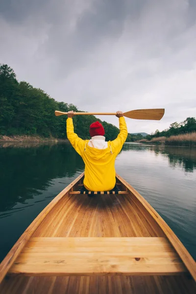 Gezgin kız gölde tahta kano kullanıyor.