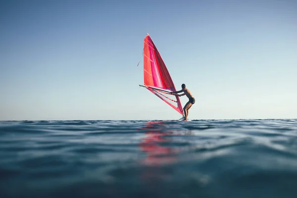 Günbatımı Denizinde Rüzgar Sörfü Yapmak Için Yelken Açan Genç Adam — Stok fotoğraf