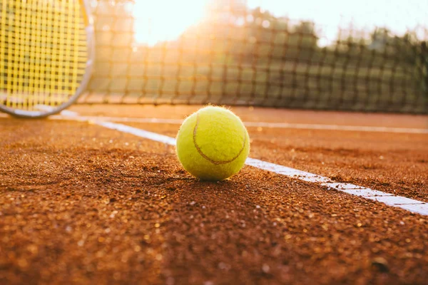 Tennis racket and ball on a clay court