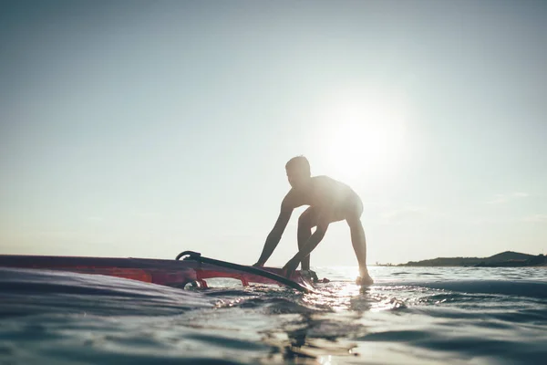 Młody Człowiek Podnosi Żagiel Deski Windsurfingowej Surfer Balansowanie Desce Windsurfingowej — Zdjęcie stockowe