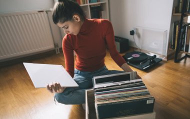 Vinil plak dinliyorum. Hippi kız evinde en sevdiği plağı arıyor.