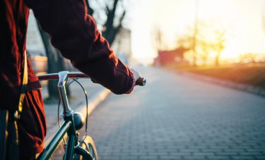 Gün batımında bisiklet sürmek. Bisiklet sürerken alçak açı